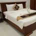 Volga Apartment Hotel in Mũi Né bedroom with a neatly made double bed and bedside phone