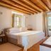 Herdade da Malhadinha Nova - Relais & Châteaux bedroom with bathtub, wood beams and window in Beja