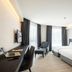 Travelodge Phuket Town room in Phuket City with two beds, desk, chairs and tall windows