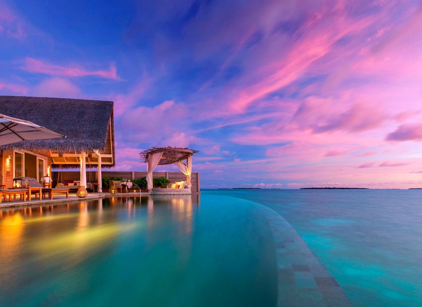 Milaidhoo Maldives in Kamadhoo, beachfront overwater villa with infinity pool at sunset