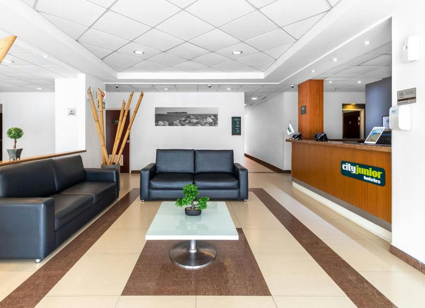 City Express Junior by Marriott Veracruz Aeropuerto lobby with black sofas and front desk