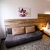 Petul Apart Hotel Am Ruhrbogen in Bochum room with sofa, double bed and wood headboard