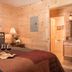 Sterling Ridge Resort in Jeffersonville: cozy wood-paneled bedroom with king bed, lamp, and adjoining bathroom