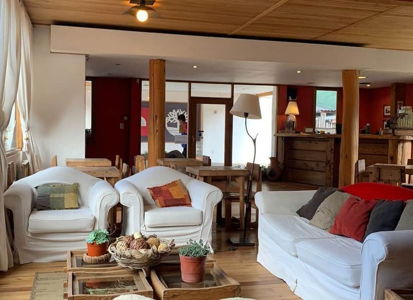 Hosteria Posta de los Colonos in Villa La Angostura living room with white armchairs and wooden tables