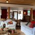 Hosteria Posta de los Colonos in Villa La Angostura living room with white armchairs and wooden tables