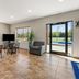 Americas Best Value Inn Byhalia lobby seating area with TV, windows, and pool view through glass doors