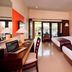 The Arnawa Hotel Pangandaran guest room with two beds, desk, balcony doors, and pool view