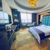 Huangtai International Hotel Jinan guest room with king bed, armchair, large window and TV
