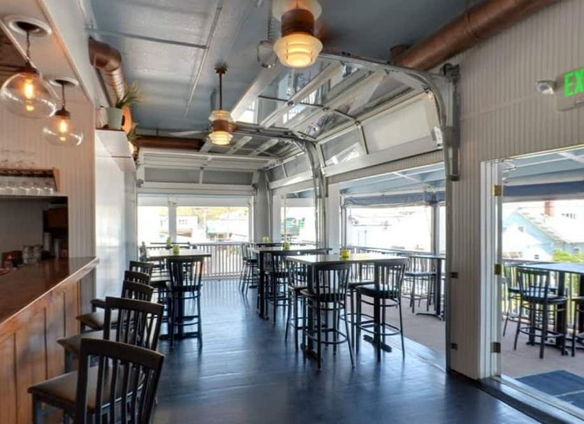 Inn on the Blues in Ogunquit: bright bar and dining area with high tables, stools, and open garage-style windows