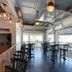 Inn on the Blues in Ogunquit: bright bar and dining area with high tables, stools, and open garage-style windows