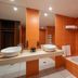 Exe Convention Plaza Madrid bathroom with orange tile walls, double sinks, mirror, and bathtub in Madrid