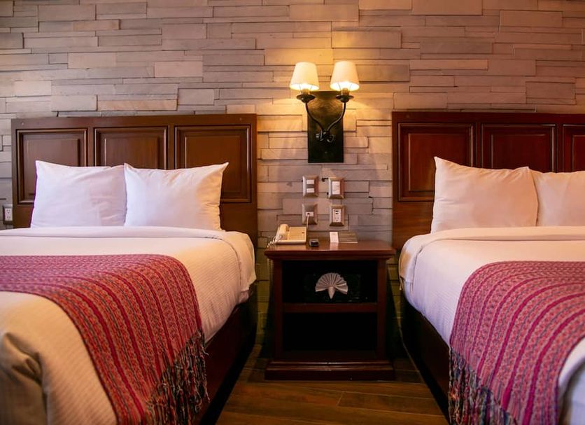 Hotel Alameda Centro Historico in Morelia: twin beds with red throws in a cozy guest room