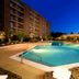 Oakwood Falls Church outdoor pool at dusk with apartment-style hotel building and lounge chairs in Falls Church