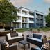 Courtyard by Marriott Fairfax Fair Oaks exterior courtyard with outdoor seating and a modern hotel facade in Fairfax