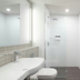 Abode Woden Canberra bathroom with walk-in shower, vanity sink, toilet and white tiled walls