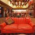 The Q Hotel & Suites Springfield lobby with red leather sofa, wood-paneled walls, and chandeliers