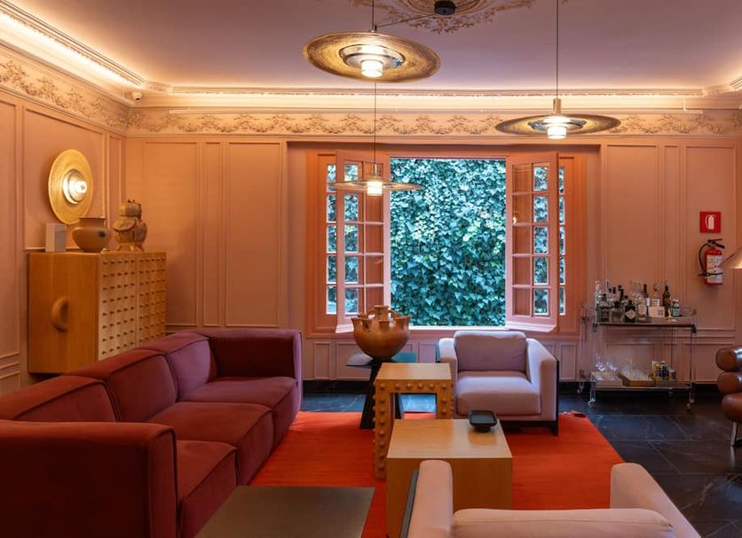 Ignacia Guest House, Mexico City lounge with red sofa, armchairs, open windows, and warm lighting