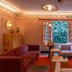 Ignacia Guest House, Mexico City lounge with red sofa, armchairs, open windows, and warm lighting