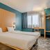 B&B HOTEL Maubeuge-Louvroil room in Louvroil with twin beds, teal walls and a window desk