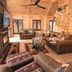 Motel Long Lake and Cottages living room with leather sofas, wood ceiling, ceiling fan, and staircase in Long Lake