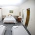 Champagnat Praia in Vila Velha: simple guest room with double bed, twin beds, desk and curtains
