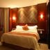 Oasis Tower Shanghai guest room with bed, armchair, warm lighting, and curtains