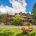 Hotel Mountain Brook in Tannersville with a lodge-style exterior, lawn chairs, and mountain backdrop