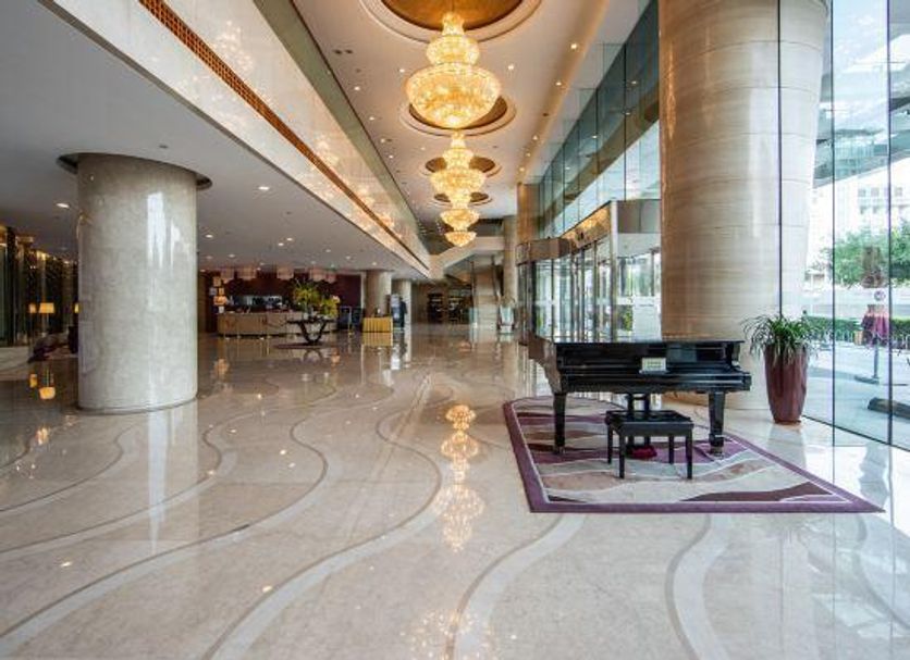 Hua Bin International Hotel Beijing lobby with grand chandeliers, piano and polished marble floors