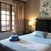 Royal Game Guest House in Phalaborwa: bedroom with king bed, bedside lamps, floral art and window view