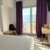 Hotel Mediterráneo by Croma in Estepona bedroom with sea view through balcony doors and purple curtains