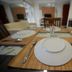 High Point Surabaya dining table set with plates and cutlery in a guest room
