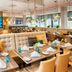 Leonardo Hotel Munich City South restaurant with modern dining area and colorful wall art
