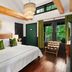 Hotel Mountain Brook, Tannersville guest room with wood-beamed ceiling, king bed, and forest view