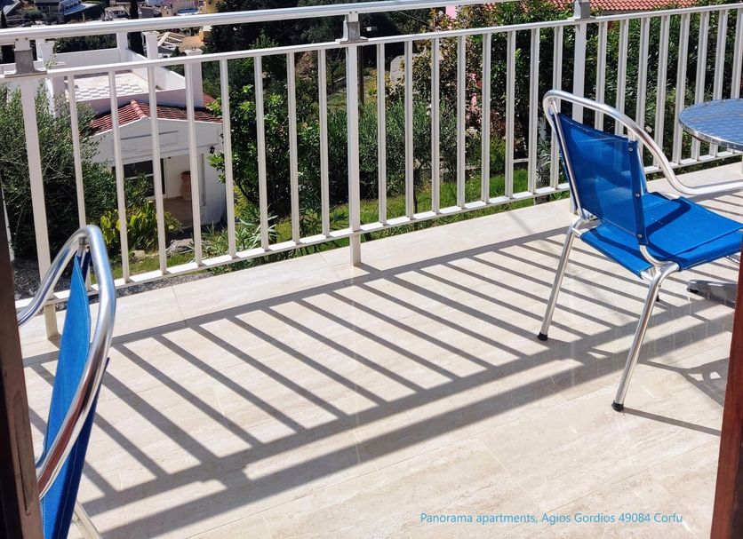 Panorama apartments in Agios Gordios with balcony sea view, mountains, and outdoor chairs