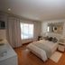 The Munday - B&B in Bedfordview bedroom with bed, mirrored wall decor, wood floor and window curtains