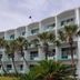 Casa Loma in Panama City Beach, three-story beachfront hotel with palm trees and balconies