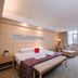 Taizhou Chunlan Hotel guest room with king bed, chaise lounge, desk and window seating in Taizhou