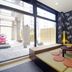 Oakhostel Zen Tokyo lounge with low tatami seating, round cushions, patterned wall and floor-to-ceiling windows