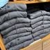 Folded gray and black jackets displayed on shelves at Super Hotel Jr Ueno Iriyaguchi, Tokyo