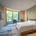 Expo Garden Resort Hotel Jinan guest room with king bed, seating area, and large window view