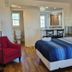 Studio 1 Motel Daytona Beach room with king bed, red chair, and kitchenette alcove
