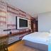 Guest room at Gem Hotel Nanjing Dachang Xinhua Road Pedestrian Street with wall-mounted TV and bed