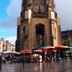 C'est une maison bleue in Bordeaux beside a historic church with colorful market umbrellas