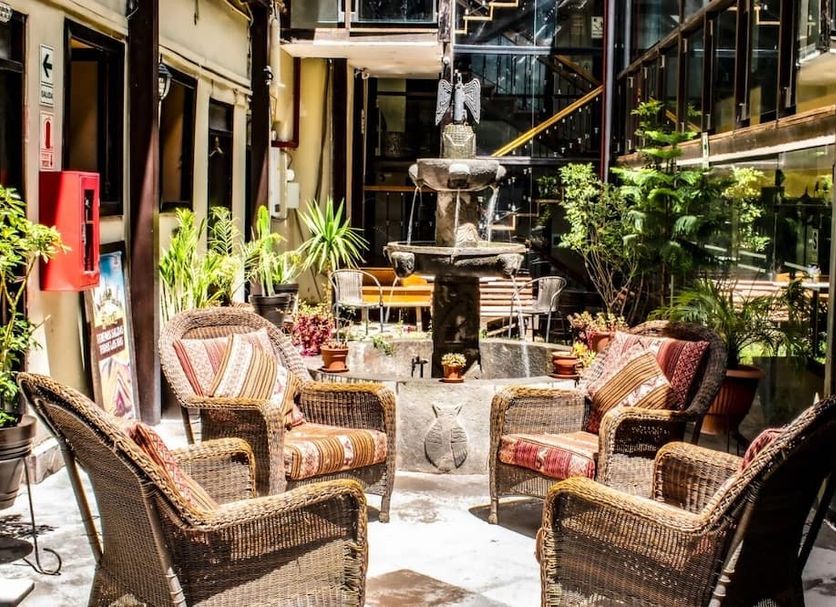 Hotel Royal Qosqo in Cusco: indoor courtyard with wicker chairs and a central fountain