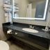 Days Inn by Wyndham Jefferson City bathroom with granite vanity, mirror, sink, and toilet