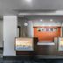 Motel 6 Augusta Ks front desk reception area with orange accent wall and hanging pendant lights