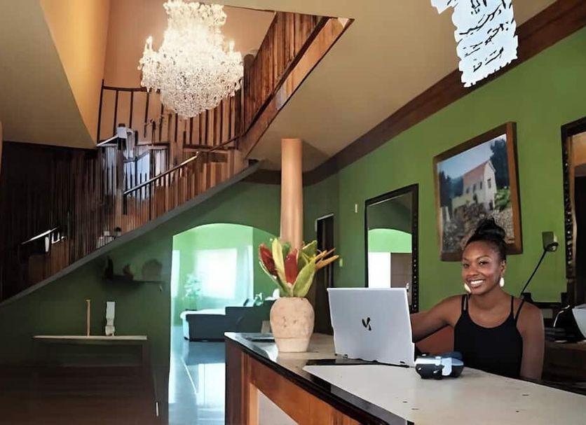 Emerald Sea View hotel lobby in Montego Bay with green walls, chandelier, staircase and front desk