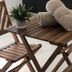 The Beach Guesthouse in La Torre: wooden balcony table with rolled towels and potted plant