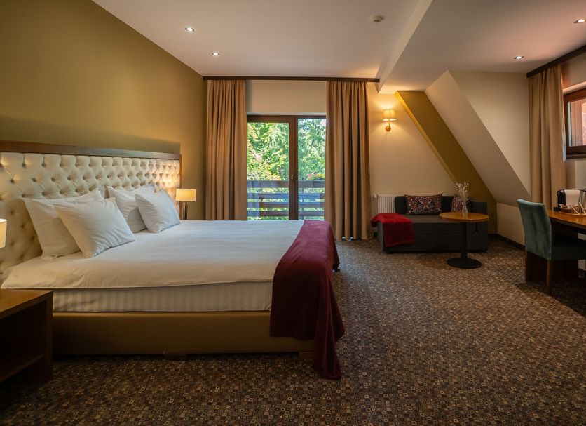 Opus Villa Sinaia guest room with king bed, balcony doors, seating area and desk