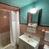 Best Motel Bowling Green bathroom with tub-shower combo, white vanity and mirror